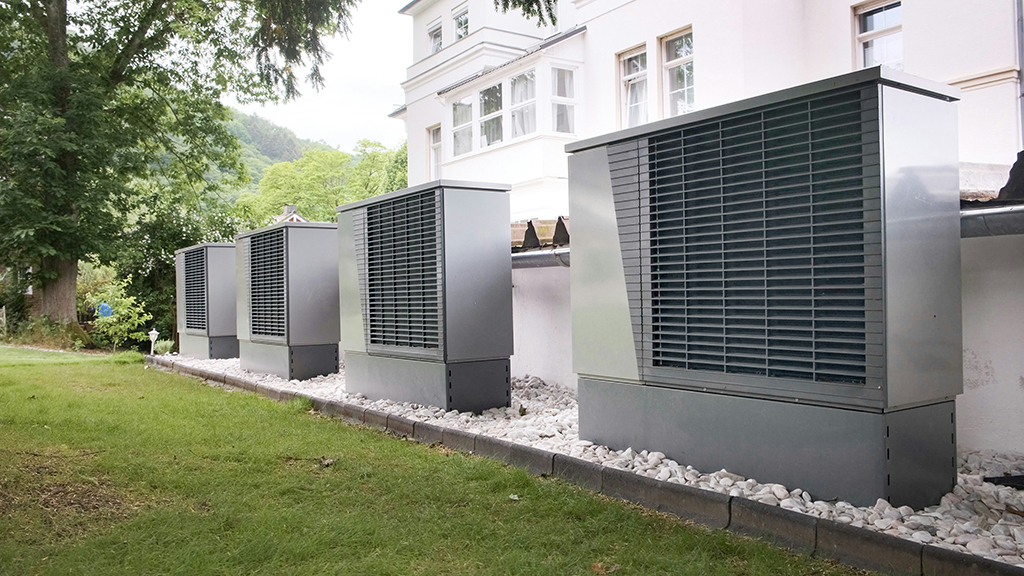 Row of heat pumps outside of a building. Unspalsh license-free image https://unsplash.com/photos/four-industrial-air-conditioning-units-lined-up-outside-building-thIufsr8kwg